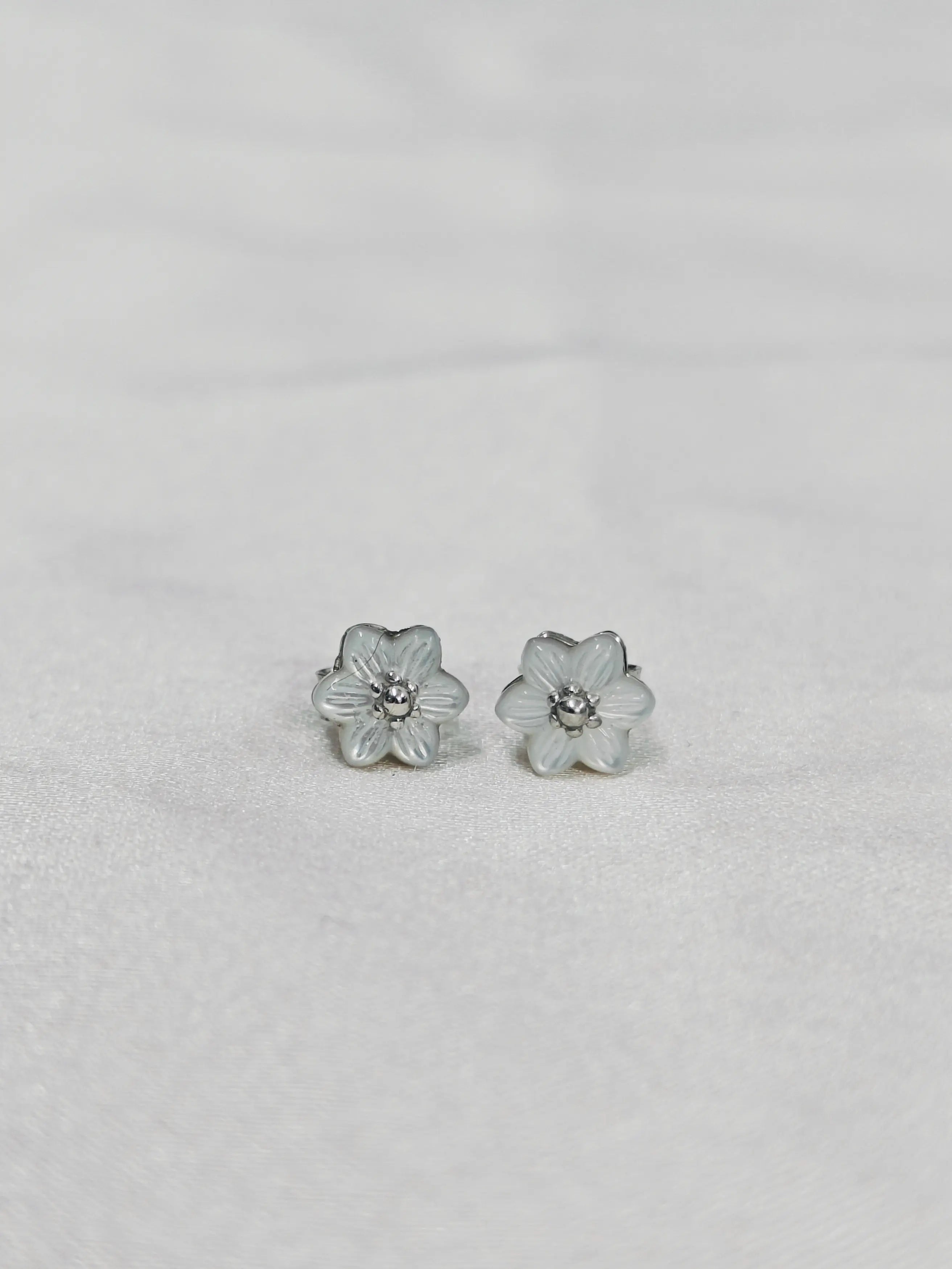 Flower-shaped earrings on a light gray background